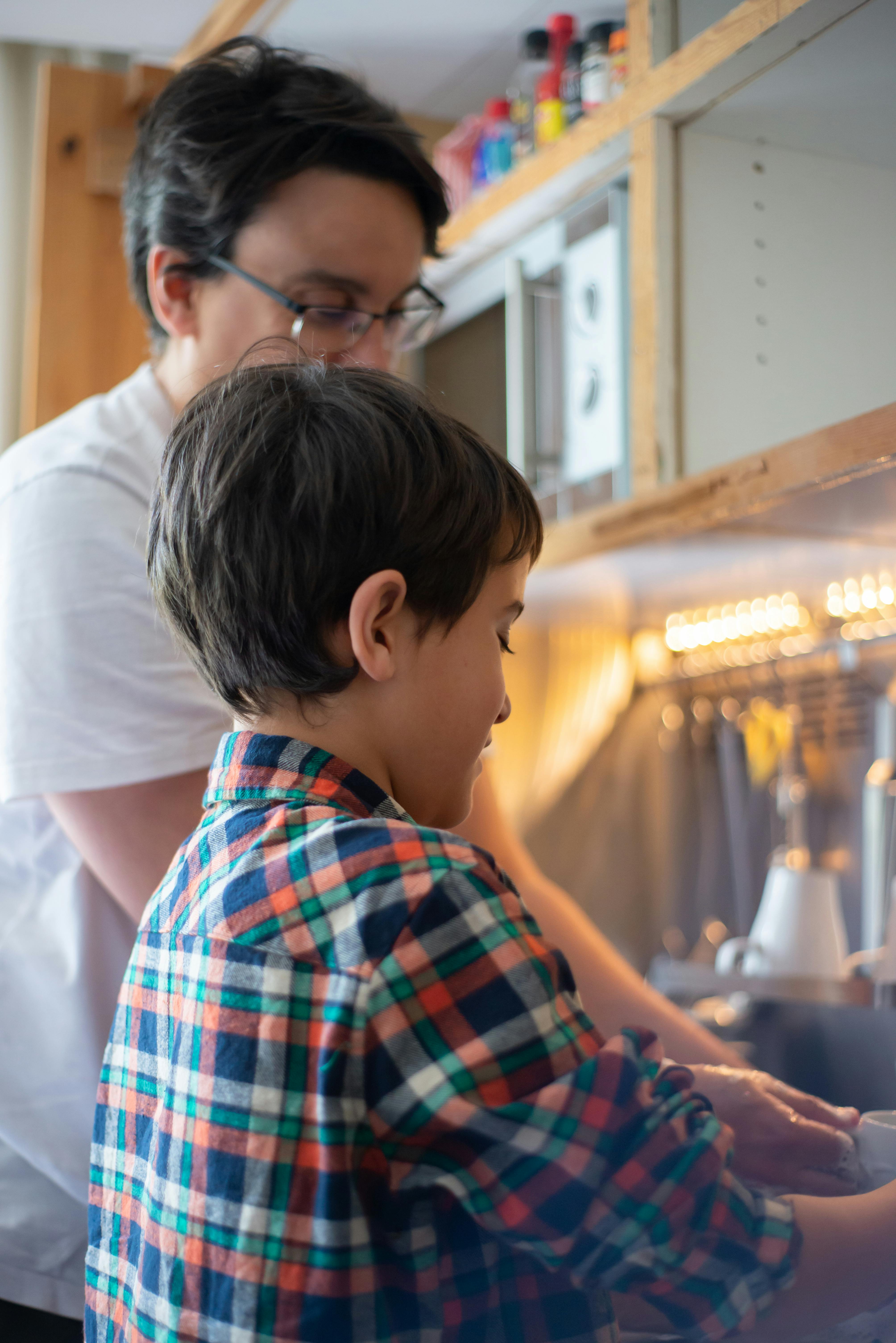 A father and son washing dishes together.