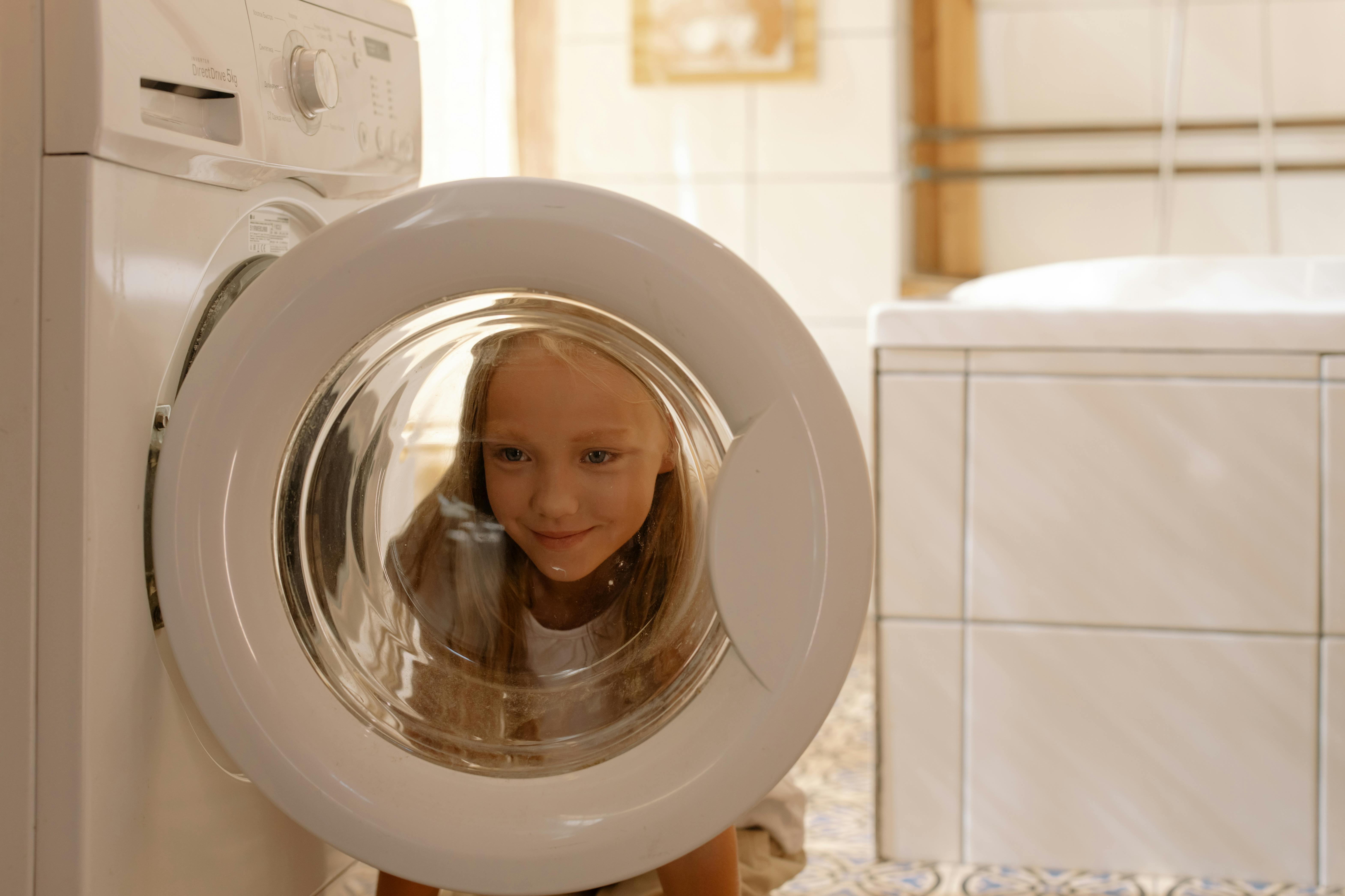 A girl helping with laundry in a bright home setting.