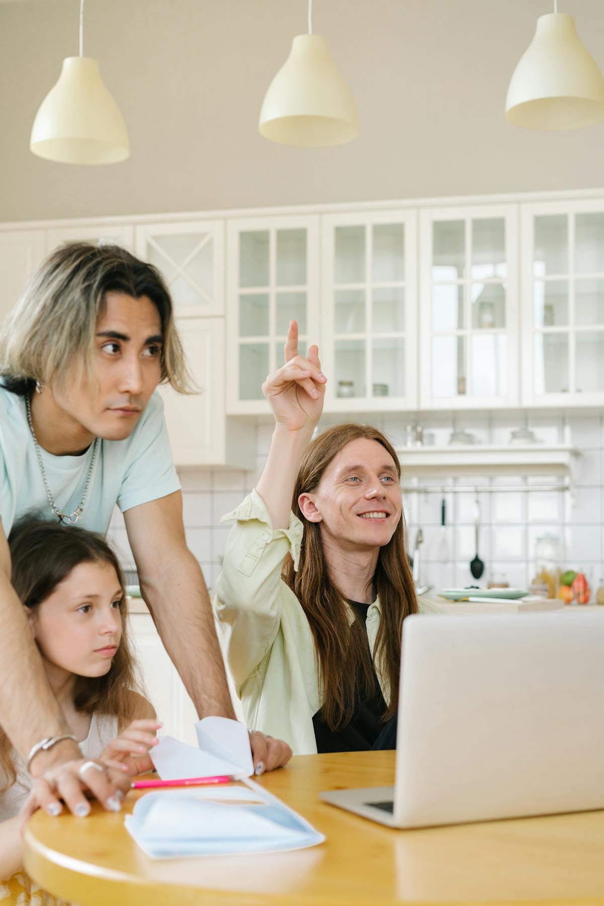 A family gathered around a laptop at the kitchen table, brainstorming together